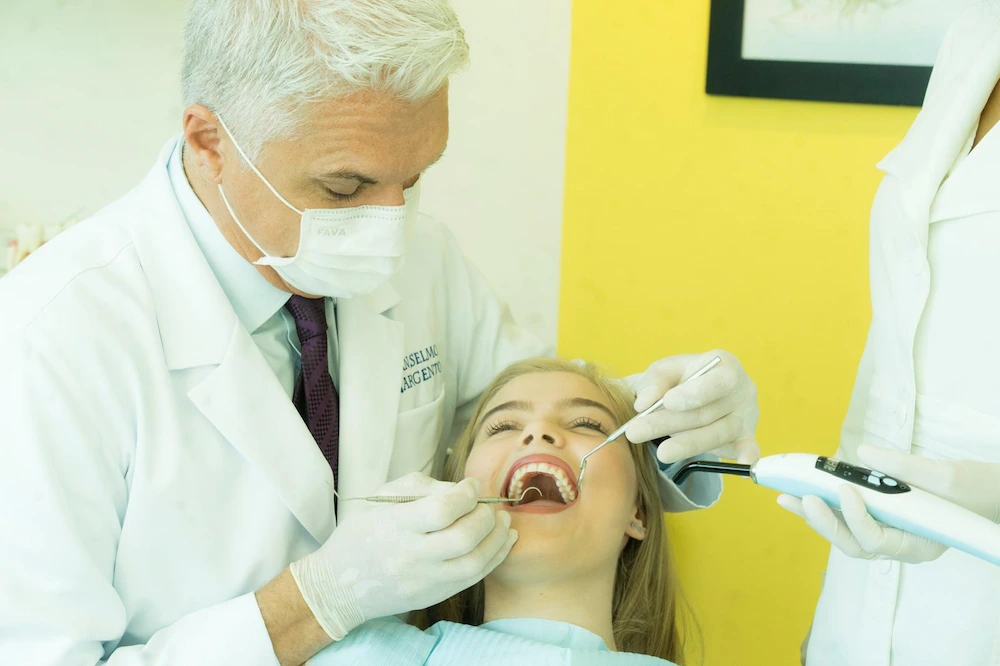 Dr. Anselmo Argento realizando uma avaliação com espelho odontológico